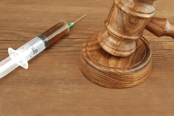 Judges Gavel And Syringe On Wood Rough Background — Stock Photo, Image