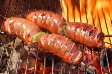Two Skewers With Sausage On The Hot BBQ Flaming Grill clipart