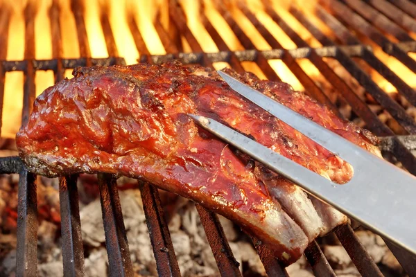 Costelas sobresselentes de porco na churrasqueira em chamas quente — Fotografia de Stock