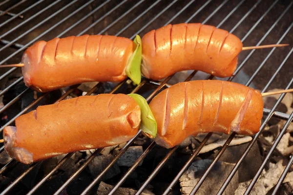 Sabrosas salchichas en la parrilla de carbón de barbacoa caliente — Foto de Stock