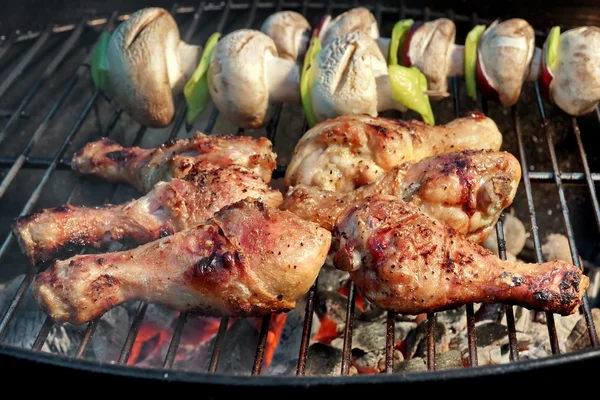 Pernas de frango churrasco e cogumelos na grelha de carvão quente — Fotografia de Stock