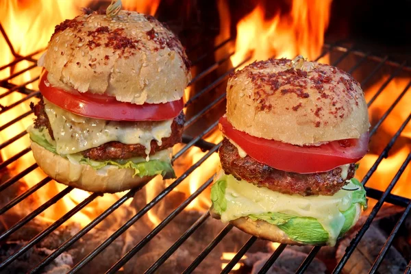 Dois Cheeseburgers caseiros na churrasqueira flamejante — Fotografia de Stock