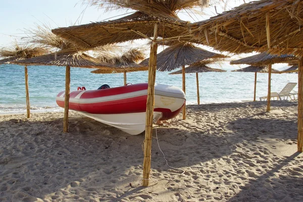 Rot-weißes Schnellboot unter Sonnenschirm — Stockfoto