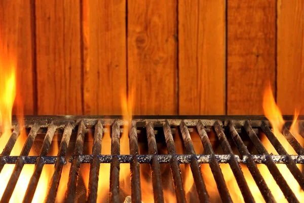 Boş Barbekü Izgara yanan ve ahşap duvar içinde belgili tanımlık geçmiş — Stok fotoğraf