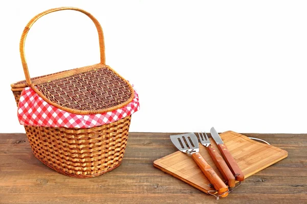 Cesta de picnic y herramientas de parrilla en la mesa al aire libre aislado —  Fotos de Stock