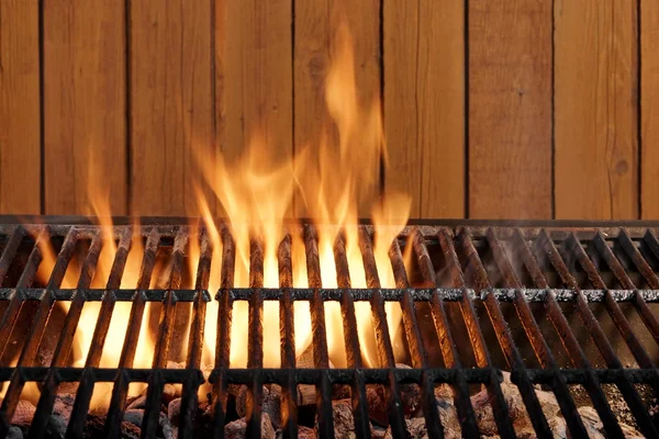 Grătar de cărbune gol în flăcări la peretele din lemn — Fotografie, imagine de stoc