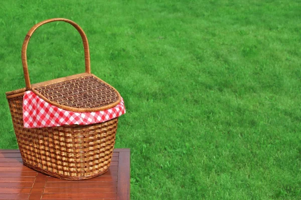 Picknickkorb auf dem rustikalen Holztisch im Freien in Nahaufnahme — Stockfoto