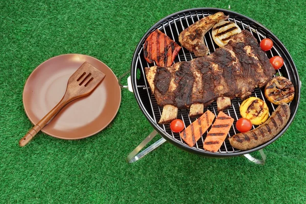 Tragbarer Grill mit Fleisch- und Gemüsesortiment von oben — Stockfoto