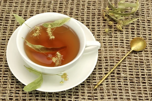 Tea Cup With Herbal Tea And  Spoon On The Tablcloth — Stock Photo, Image