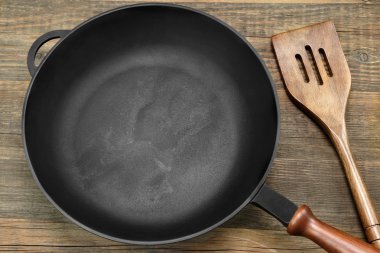 New Clean Empty Cast Iron Frying Pan And Spatula Overhead clipart