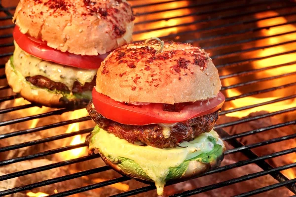 Cheeseburgers caseiros no churrasco quente flamejante — Fotografia de Stock