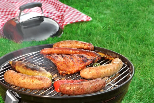 Primer plano de barbacoa parrilla y manta de picnic en el fondo —  Fotos de Stock