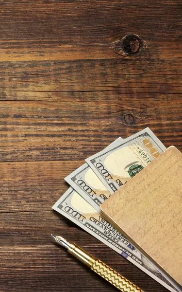 Fondo vacío de madera con cuaderno, dinero y pluma de oro —  Fotos de Stock