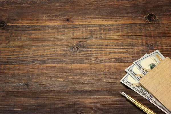 Holz leerer Hintergrund mit Notizbuch, Geld und goldenem Stift — Stockfoto