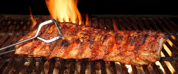 Baby Back or Pork Spareribs on the Hot Flaming Grill Стоковая Картинка