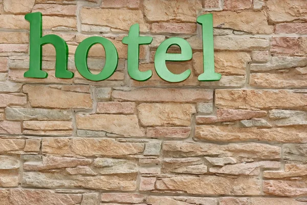 Hotelschild an künstlicher Steinmauer — Stockfoto