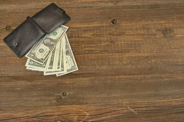 Ανδρικό πορτοφόλι με Δολάριο μετρητά στο τραχύ ξύλο παρασκήνιο — Φωτογραφία Αρχείου