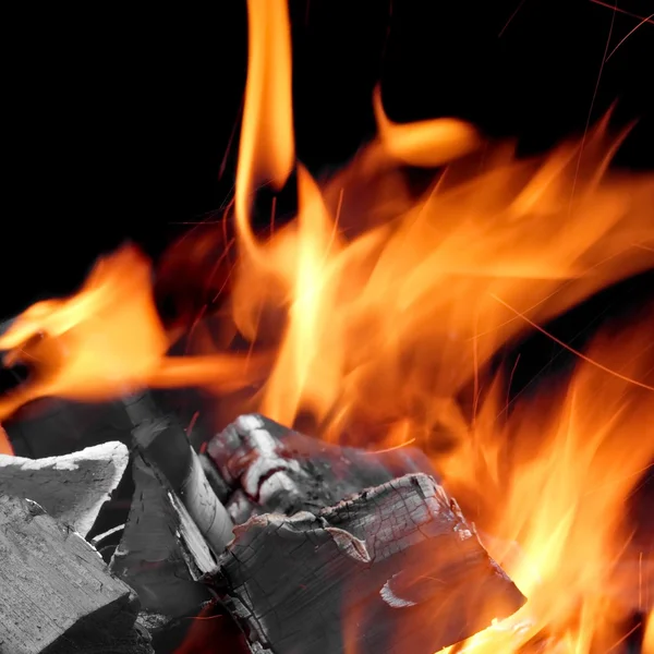 Carvão brilhando com chamas de fogo isolado no preto — Fotografia de Stock