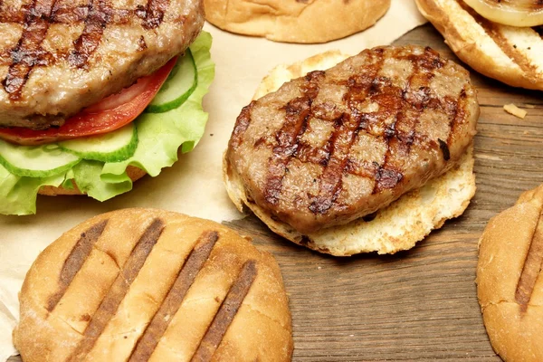 Top de mesa de piquenique com churrasco grelhados hambúrgueres e legumes — Fotografia de Stock