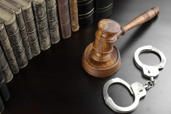 Judges Gavel, Handcuffs And Old Book On The Black Table — Stockfoto