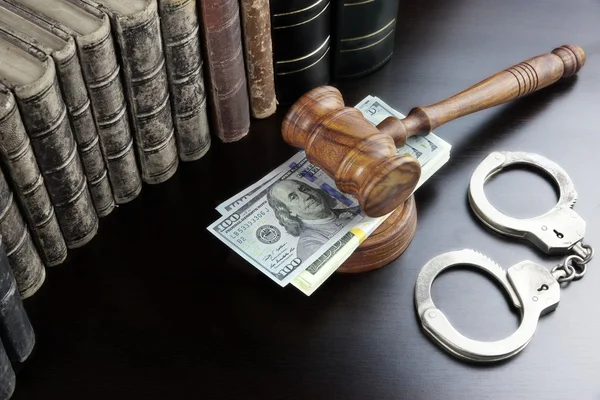 Juízes Gavel, algemas, dinheiro do dólar e livro na mesa preta — Fotografia de Stock