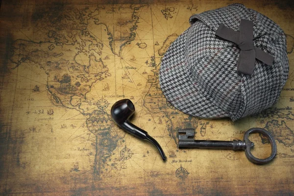 Deerstalker Sherlock hoed, vintage sleutel, rookpijp op de oude kaart. — Stockfoto