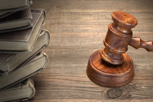 Jueces de madera martillo y libros de leyes antiguas en la mesa de madera — Foto de Stock