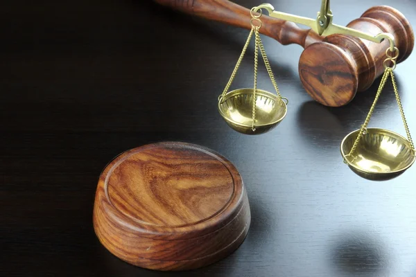裁判官小槌と黒いテーブルの上の正義のスケール — ストック写真