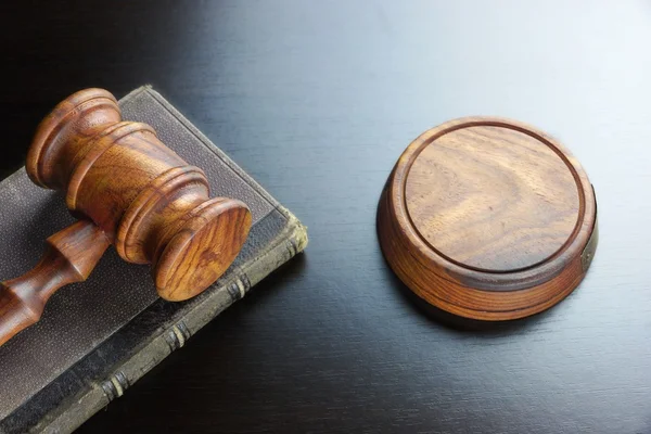 Juízes Gavel e livro antigo sobre a mesa de madeira preta — Fotografia de Stock