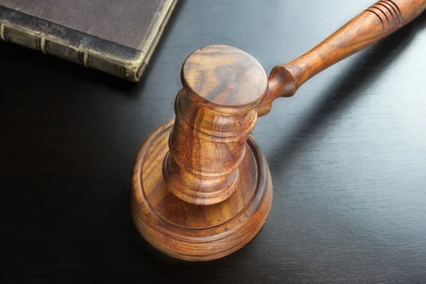 Juízes Gavel e livro antigo sobre a mesa de madeira preta — Fotografia de Stock