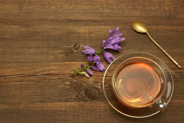 Transparent Glass Teacup And Gold Teaspoon On Rough Wood Table — Stock Photo, Image