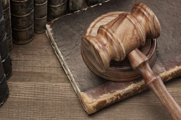 Gavel de Jydges de madera y libros antiguos de la ley en la tabla de madera — Foto de Stock