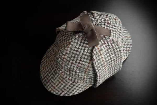 Sherlock  Holmes Deerstalker Hat On The Black Wooden Table — Stockfoto