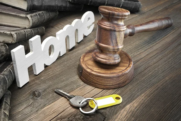 Firme en casa, llave, martillo de jueces y libro sobre mesa de madera — Foto de Stock