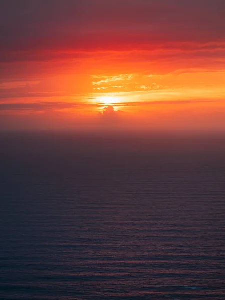 穏やかな海と大西洋の雲の後ろに沈む太陽 — ストック写真