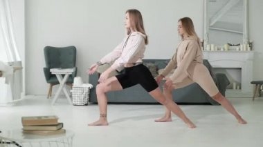 Sıska genç kızlar çalışma odasında egzersiz yapıyorlar. Savaşçı pozu veren arkadaşlar. Spor salonu izolasyonla dolu. Her gün sağlık için egzersiz. Kadınlar için spor salonu