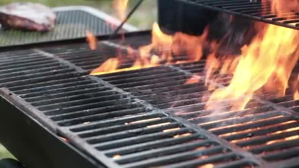 熱い鉄のグリルで牛肉肉の大規模なジューシーな塊を焙煎外バーベキューグリル シェフはトンズを使って肉とフィレステーキをグリルグレートに火と火花を散らしおいしいストリートフードを作る — ストック動画