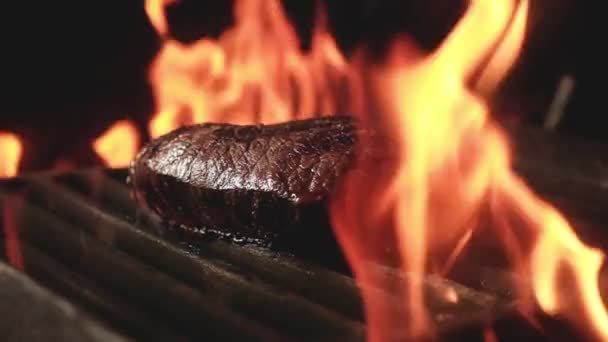 多汁的牛排软骨素在火炭上 在黑暗背景下的铁烤上煎 晚上和朋友们一起在聚会上烧烤 在篝火熊熊燃烧的篝火中烹调晚餐 — 图库视频影像