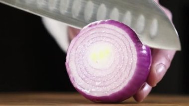 Profesyonel erkek aşçı hamburger yapmak için keskin bıçak dilimleriyle sulu taze soğanlar keser. fast food. Lezzetli hamburgerler. Yemek için malzemelerin hazırlanması. Ev yapımı sebze dilimleme