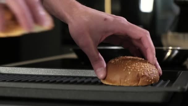 专业的男性厨师把切片面包放在热烤盘上煎 在餐馆厨房里做了一个多汁美味的汉堡包 配料的准备 有美味的自制汉堡包的烧烤 — 图库视频影像