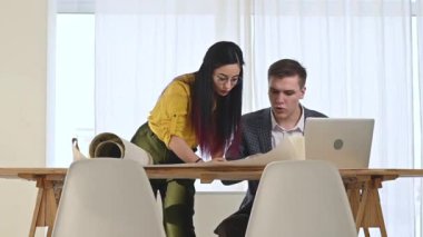Tasarım Bürosu 'nun Avrupalı mimarları ve tasarımcıları geniş ve parlak ofislerde proje planını aktif olarak tartışıyorlar. Erkek ve kadın birlikte dizüstü bilgisayardaki projeyi düzenler ve düzenlerler..