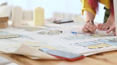 Tasarım ofisi, mimarlık şirketi. Şirketin çalışanları mimari bir yapının tasarım projesini geliştirirler. Kapanış çizimleri masaüstünde. Yönetici taslak üzerinde bir kalem ile düzenleme çizer