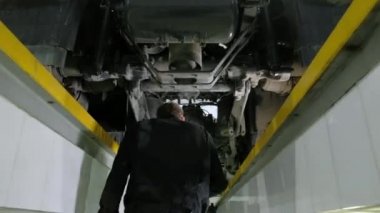 Tulumlu genç araba tamircisi kamyonun altına girer ve arabayı teftiş eder. Mühendis arızalara bakar, yedek parçalara el ile dokunur ve bütünlüklerini kontrol eder. Garaj atölyesinde kamyonların bakımı