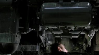 Tulumlu oto tamircisi kamyonun altına giriyor ve teftiş arabası yapıyor. Müfettiş dökümlere bakar ve onları bilgisayardaki teşhis kartına yazar. Garaj atölyesinde otomatik onarım kamyonları