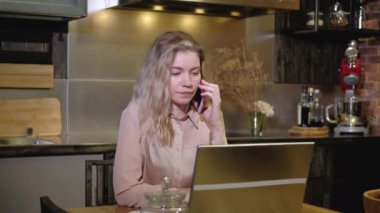 Akşam evde, mutfakta dizüstü bilgisayarda çalışan bir kızın portresi. Kadın bir serbest çalışan cep telefonuyla konuşur ve not almak için bilgisayar kullanır. Projeyi istemciyle uzaktan tartışın