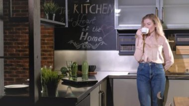 Beyaz kadın sabah kahve içer, iş yerinde laptop açar ve mesajları kontrol eder. Mutfaktaki merkez ofis. Serbest çalışan kız bilgisayardaki postaları kontrol ediyor. çevrimiçi iş geliştirme