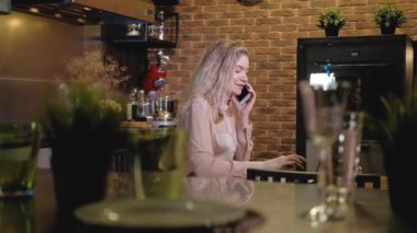 Konsantre genç kız, müşterisiyle akşamları mutfakta akıllı telefon iletişimi kuruyor ve dizüstü bilgisayarına mesaj yazıyor. Dairenin merkez ofisi. Kadın serbest çalışan telefonda konuşuyor.