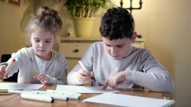 Çocuklar parlak oturma odasında kağıt üzerine renkli kalemle resimler çizerler. Anaokulu çocuk gelişimi kavramı. Çocuklara okul ve ev çizmeyi öğretmek. hayal gücünün ve yaratıcılığın gelişimi