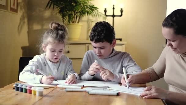 가정은 방에서 창의력을 합니다 어머니는 소녀와 소년에게 종이를 그리는 가르친다 — 비디오