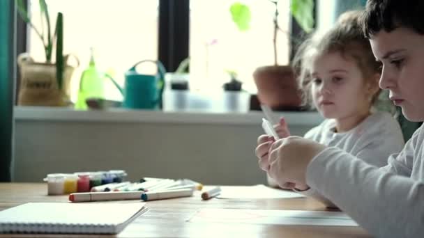 Erkek Kız Kardeş Masada Oturuyor Yaratıcı Işler Yapıyorlar Çocuklar Albümde — Stok video